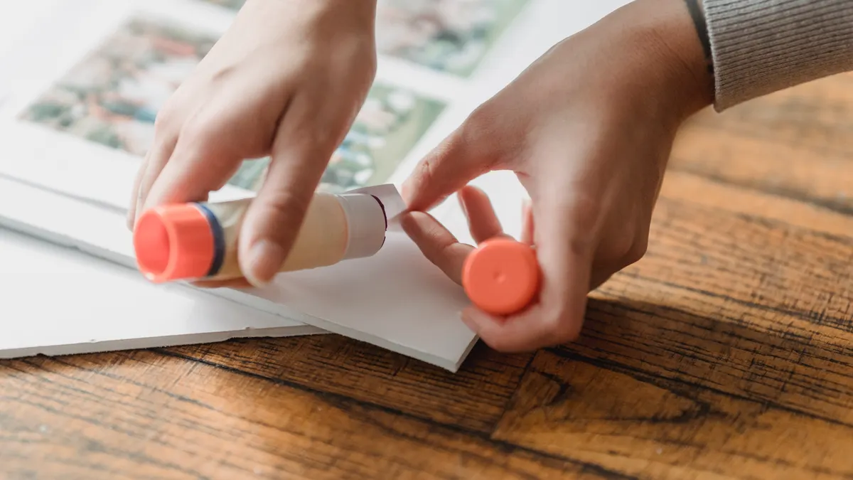 How to Choose Scrapbooking Adhesives That Won't Damage Photos Hands using a glue stick on paper
