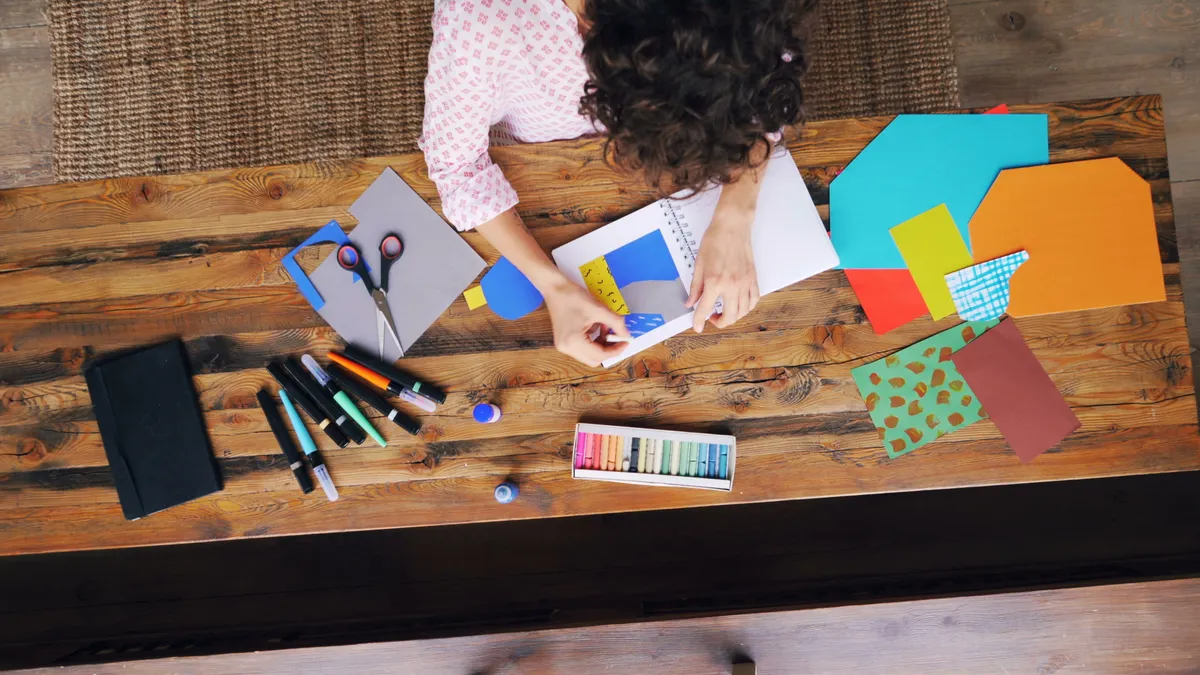 top view of hands placing paper on a scrapbook page