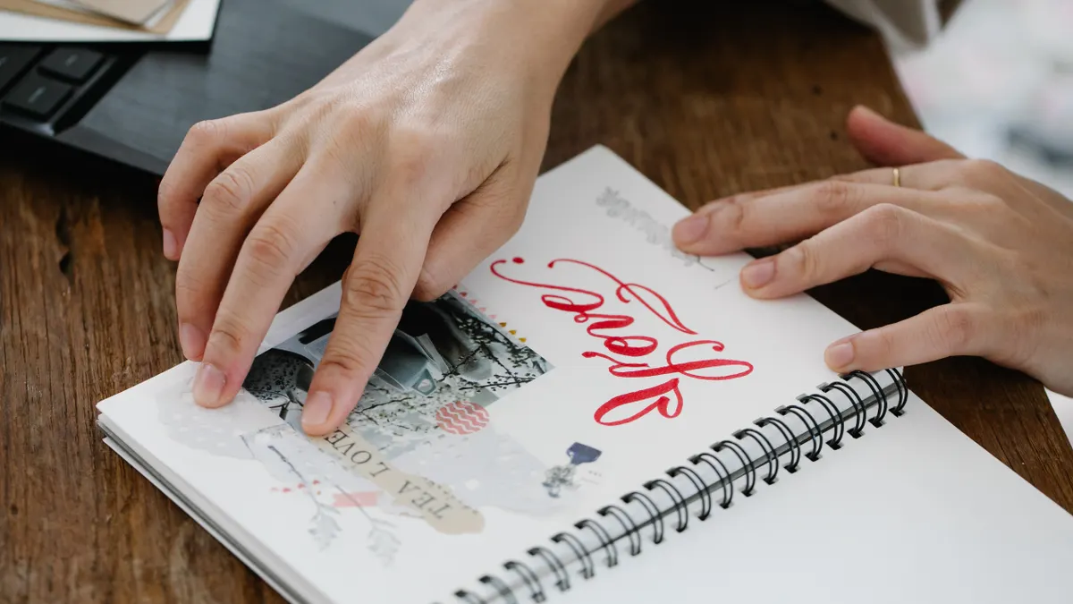 hands arranging photos in a scrapbook album