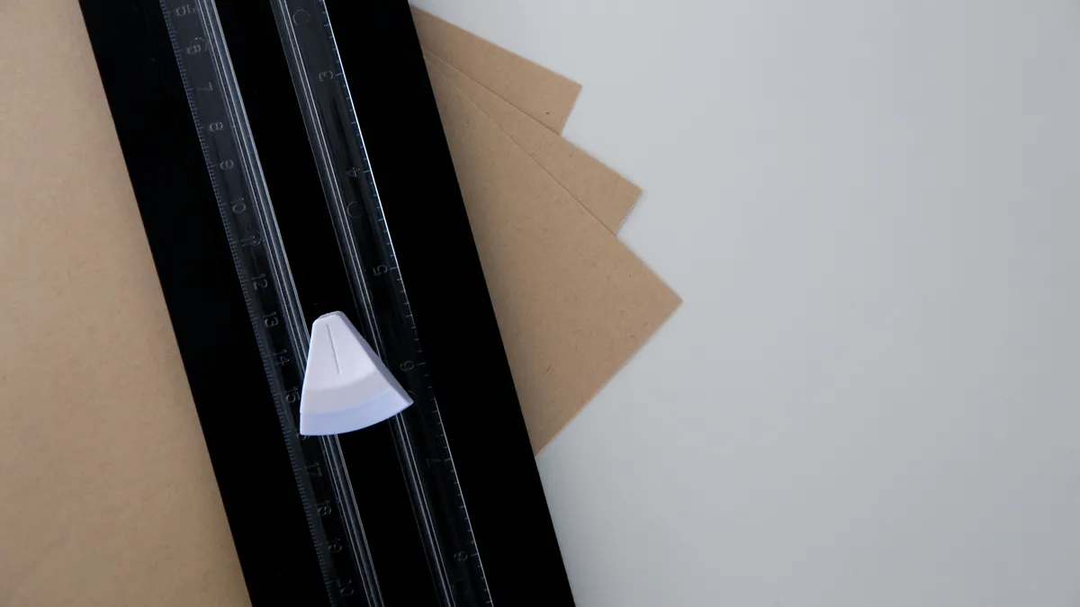 Scrapbooking Tools You Actually Need: Cutter, Trimmer, Punches, and More Paper trimmer beside cut cardstock sheets